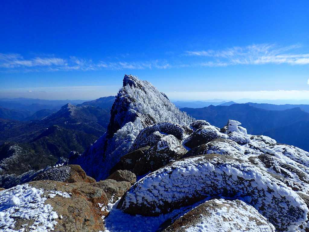ガスが飛んで青空が広がる天狗岳の右遥か遠くに剣山も